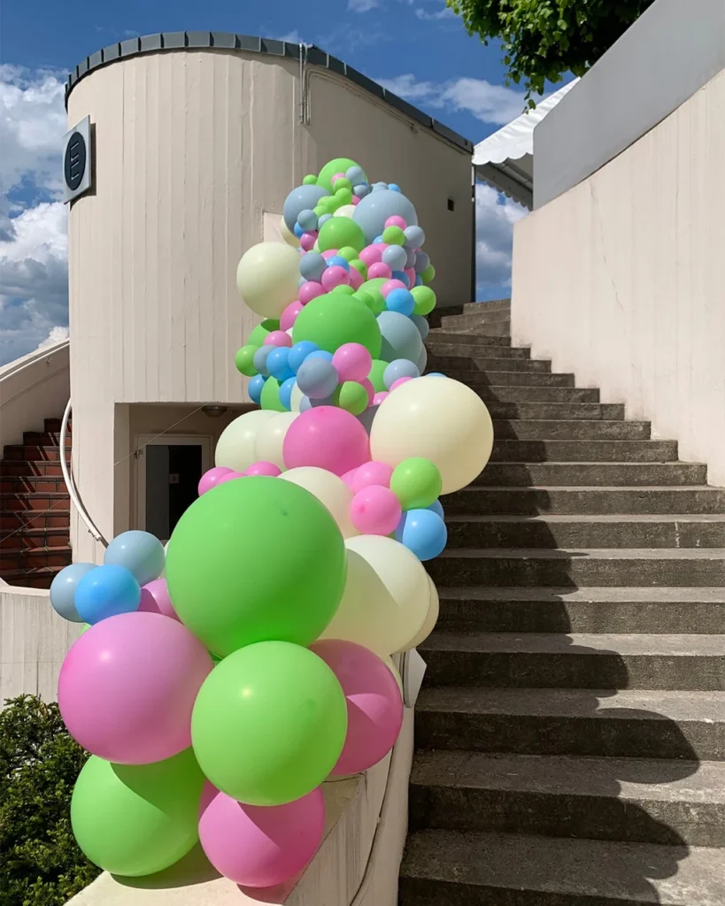 Fargerik organisk ballongdekor langs en utendørs trapp på Ekebergrestauranten
